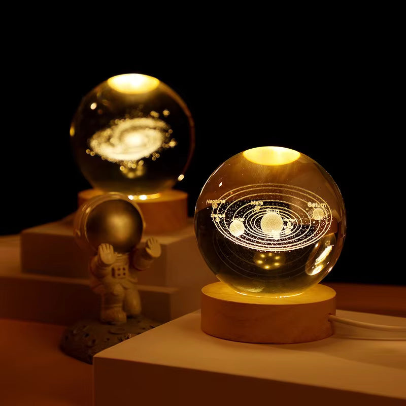 Two illuminated crystal balls on stands with a dark background